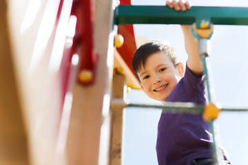 happy little boy climbing on children playground