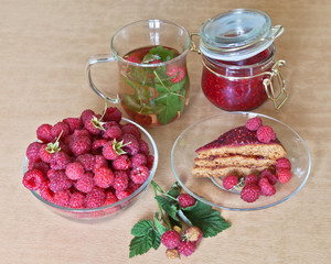 Berries ripe raspberry, green tea with raspberry leaf and a piece of layer cake with raspberry layer
