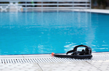 A snorkeling mask and tube near swimming pool