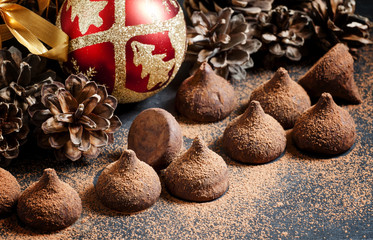 Chocolate truffles, sprinkled with cocoa powder, red Christmas b
