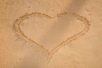 Heart drawn in the sand. Beach background. Top view