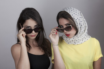 Due giovani donne con foulard a pois e occhiali da sole vintage