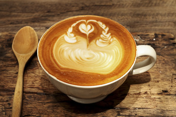Hot mocha coffee decorated on wooden background, latte art.