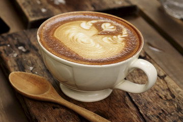 Hot mocha coffee decorated on wooden background, latte art.