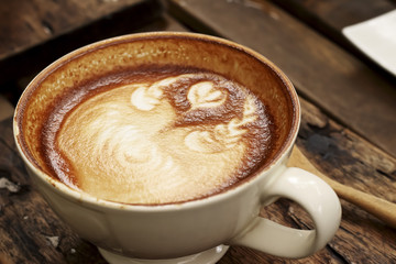Hot mocha coffee decorated on wooden background, latte art.