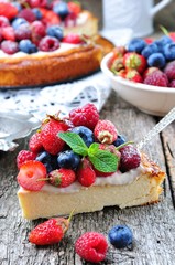 Cottage cheese casserole with fresh strawberries, blueberries, raspberries and mint and powdered sugar