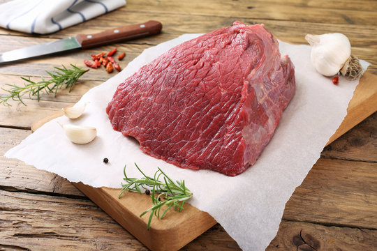carne cruda filetto di manzo con spezie su tagliere sfondo rustico