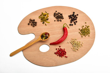 Palette of various spices on wooden palette isolated on white