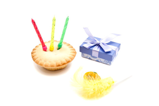 cupcake with three birthday candles, gift and whistle