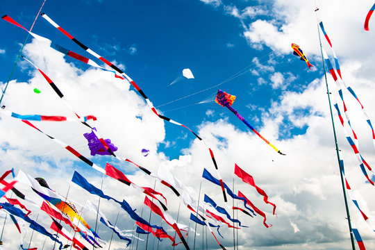 Various flags and kites flying on the blue sky