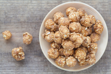 Almond and caramal popcorn on wood background