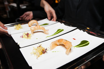 Obraz na płótnie Canvas chef put food on tray before served by waiter