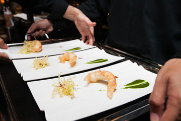 chef put food on tray before served by waiter