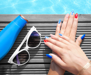 Woman lying down by the pool, marine sailor gel nails close up summer beauty concept