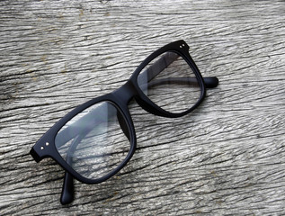 black eye glasses on wood background