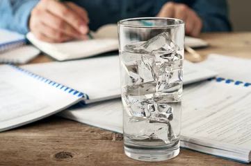  glass of water on a wooden office desk © kucherav