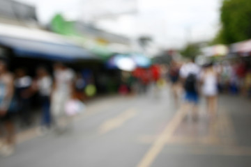 Obraz premium Blurred background : people shopping at market fair in sunny day