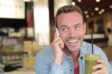 Commercial beautiful man drinking organic healthy smoothie for a perfect diet. Green food for a healthy life
