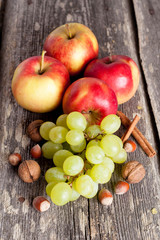 Naklejka na ściany i meble autumn fruits - the red apple and green grapes