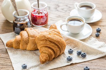 Croissants with  cups of coffee and milk