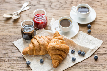 Croissants with fresh blueberry and two cups of coffee