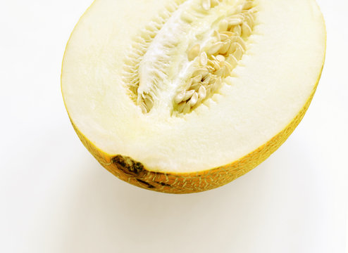 Half melon on white background, melon seeds and pulp, diagonal 