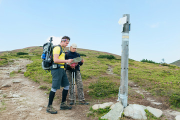 Tourists hiking with map in the mountains