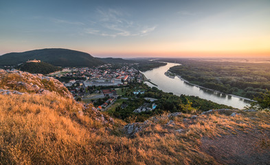 Fototapeta na wymiar View of Small City with River from the Hill at Sunset