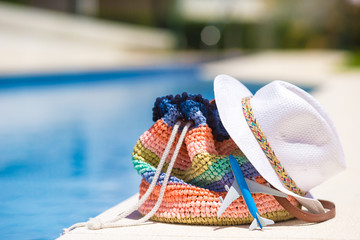 Colorful beach bag, straw hat and airplane model at summer