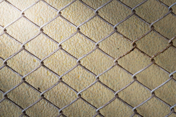 steel wire mesh fence wall background with light from corner