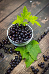 black currant in a glass bowl transparent scattered on the old w