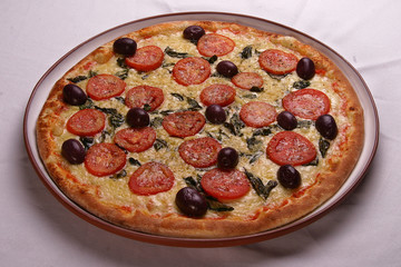 Tasty pizza, tomatoes and others ingredients on a wooden backgro