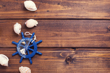 Decorative helm and marine items on wooden background.