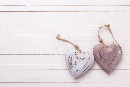 Two decorative  hearts on white  painted wooden background