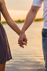 Happy couple holding handsin the sunset