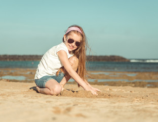 little girl in a hat on the  beach