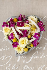 Floral arrangement with roses and orchids in heart shape