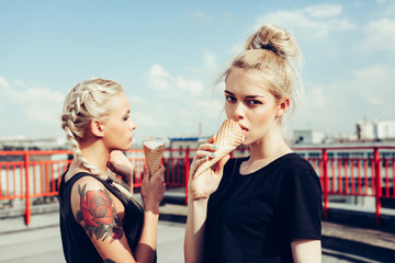 two sensuality young beautiful girls eating ice-cream