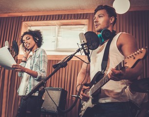 Multiracial music band performing in a recording studio