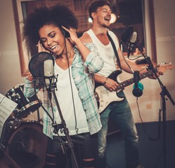 Multiracial music band performing in a recording studio