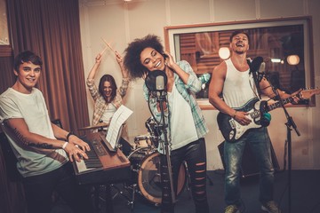 Fototapeta premium Multiracial music band performing in a recording studio