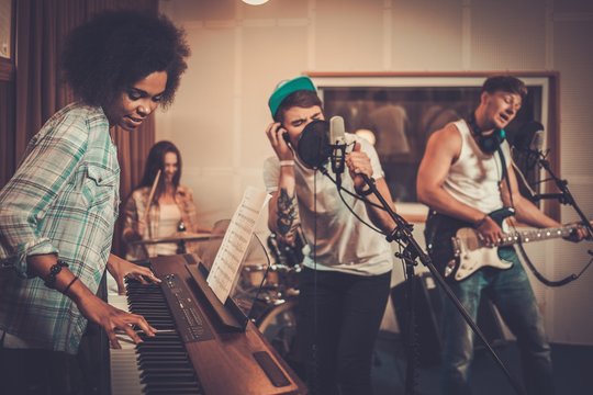 Multiracial music band performing in a recording studio