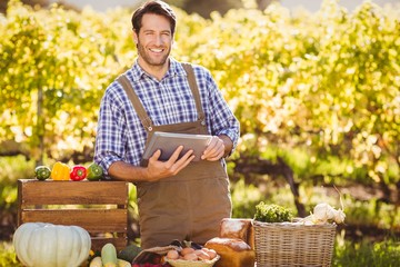 Smiling farmer using a digital tablet