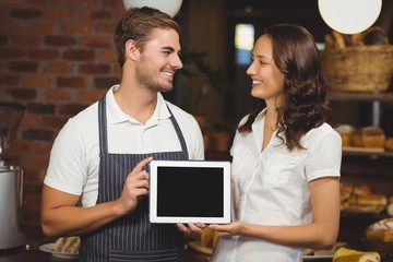 Smiling co-workers showing a tablet