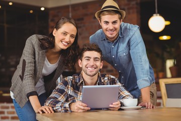 Smiling friends using tablet computer