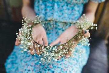Girl holds head wreath in hands