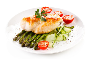 Roast chicken fillet and vegetables on white background 