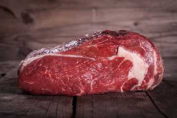 Beef on wooden table over wooden background