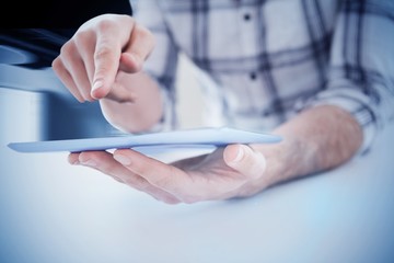 Composite image of casual man using tablet pc