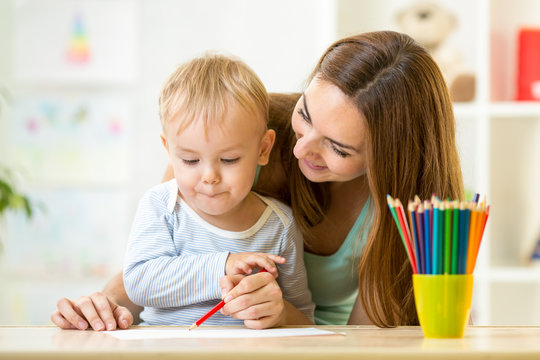 cute child drawing with mother help